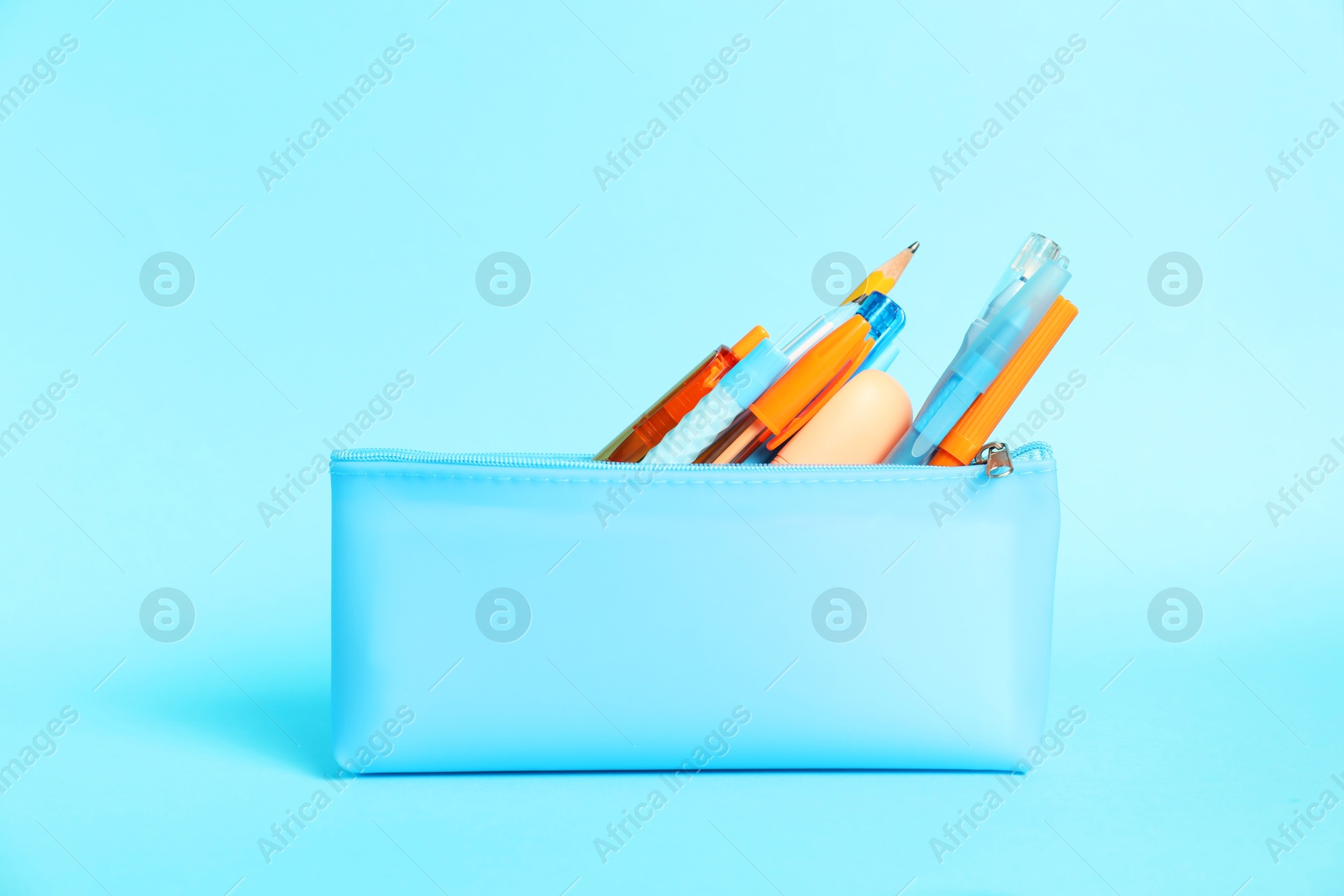 Different stationery in pencil case on light blue background Photo of Different stationery in pencil case on light blue background