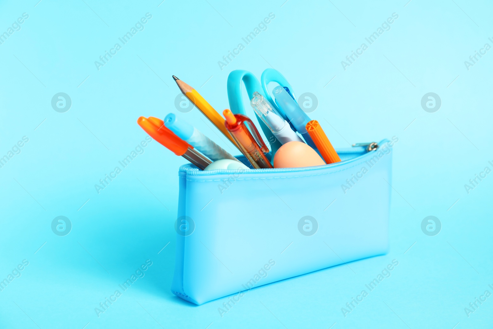 Different stationery in pencil case on light blue background, closeup Photo of Different stationery in pencil case on light blue background, closeup