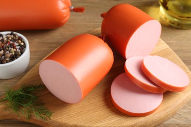 Photo of Tasty boiled sausages and spices on wooden table, closeup