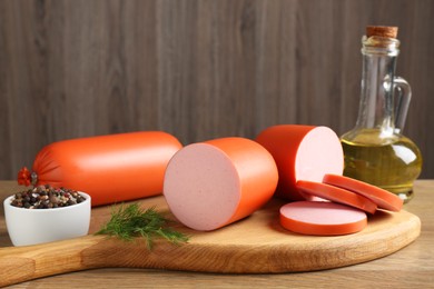 Photo of Tasty boiled sausages and spices on wooden table