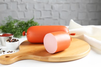 Photo of Tasty boiled sausages and spices on white table