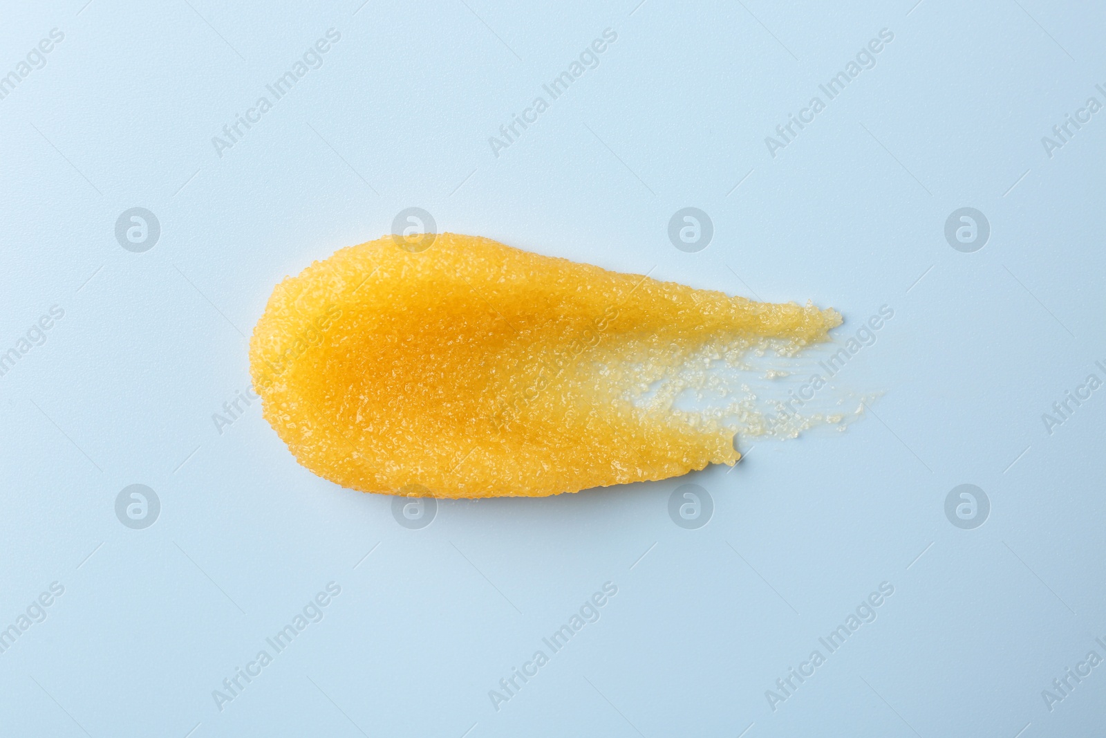 Photo of Smear of body scrub on light background, top view