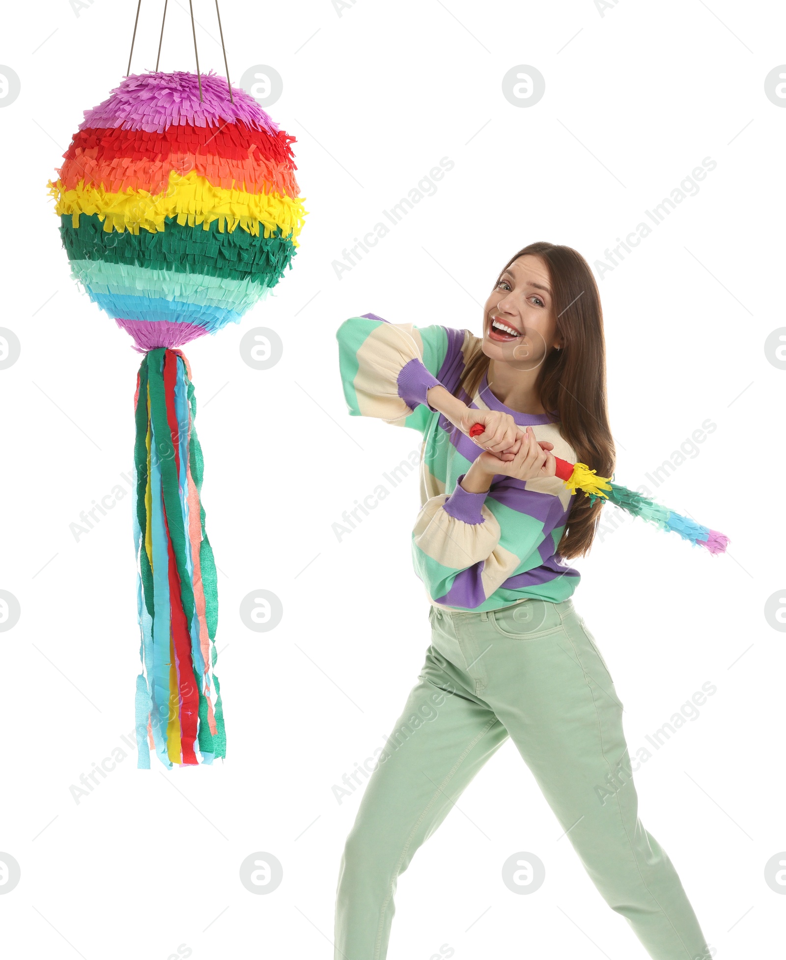 Photo of Happy woman breaking colorful pinata with stick on white background