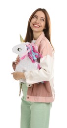 Happy woman with unicorn shaped pinata isolated on white