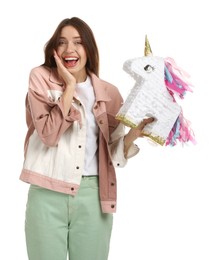 Photo of Emotional woman with unicorn shaped pinata isolated on white