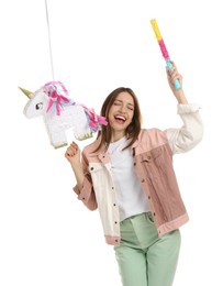 Photo of Happy woman with unicorn shaped pinata and stick isolated on white