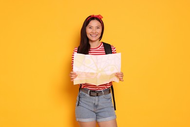 Photo of Happy traveller with map on yellow background