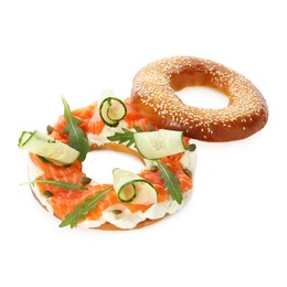 Photo of Delicious bagel with salmon, cream cheese and cucumber isolated on white