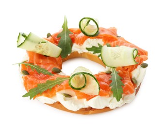 Photo of Half of delicious bagel with salmon, cream cheese and cucumber isolated on white