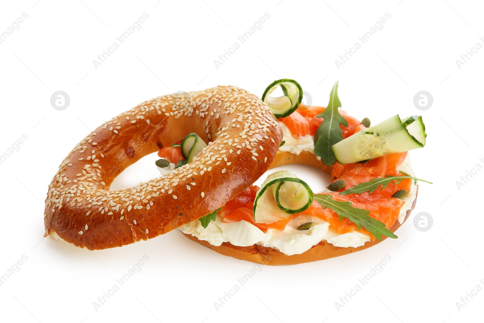 Photo of Delicious bagel with salmon, cream cheese and cucumber isolated on white