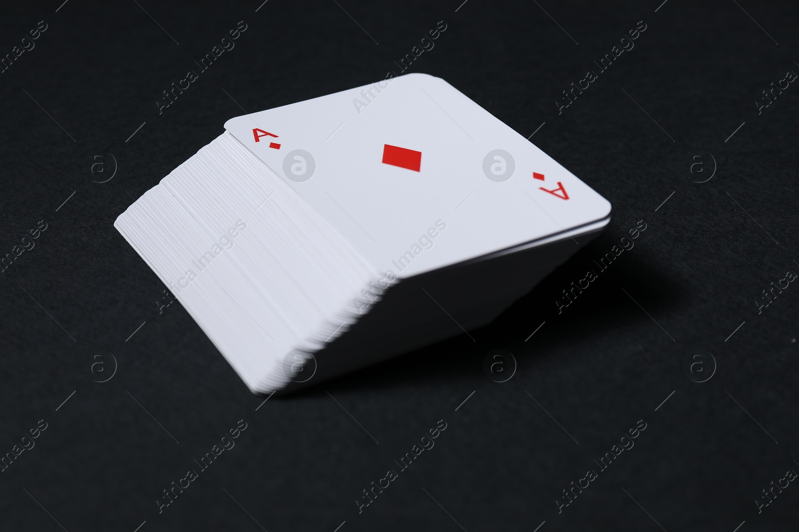 Photo of Deck of playing cards on black background, closeup