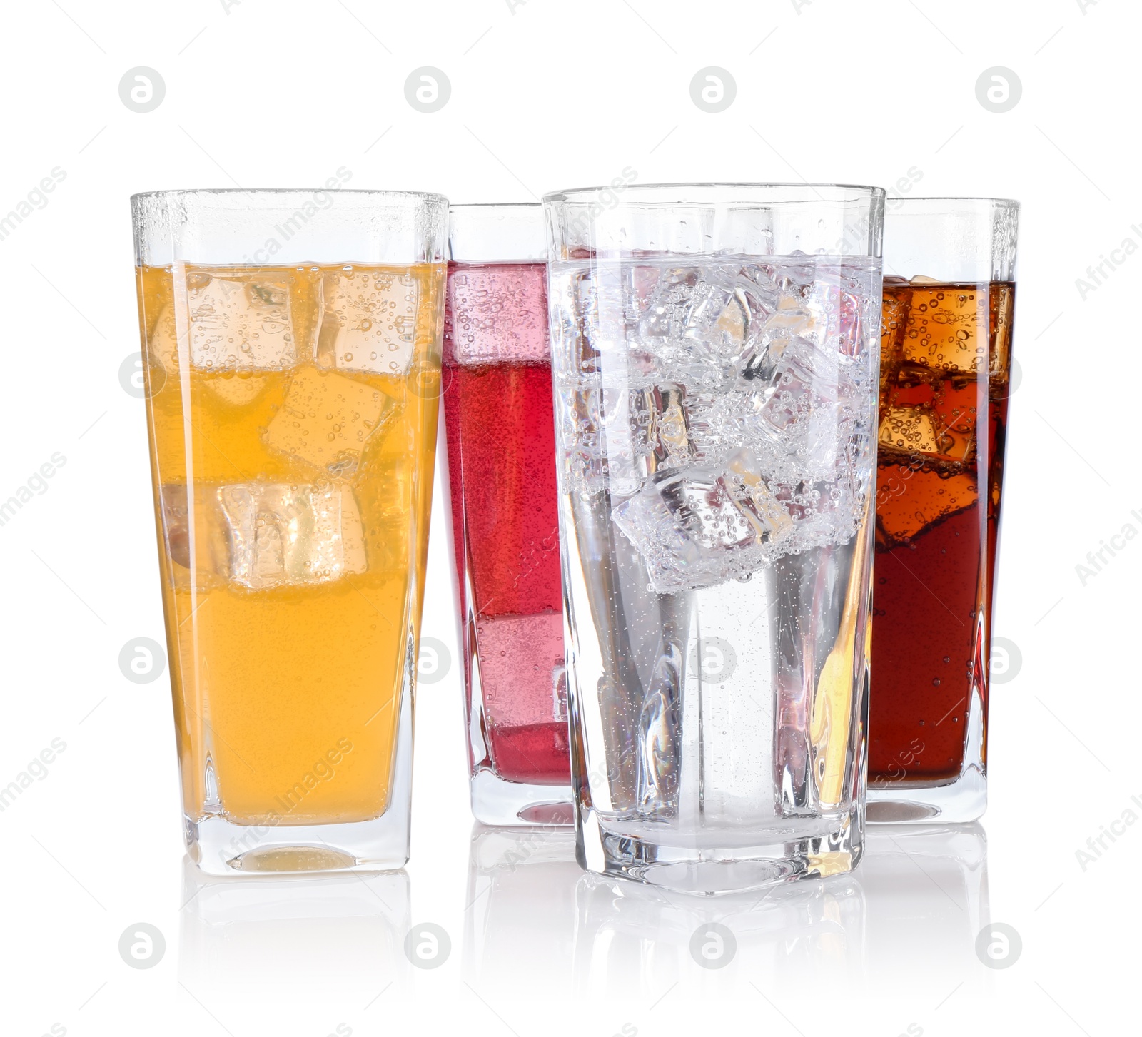 Photo of Soda water of different flavors with ice cubes in glasses isolated on white