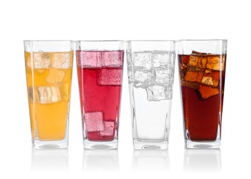 Photo of Soda water of different flavors with ice cubes in glasses isolated on white