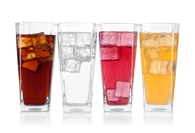 Photo of Soda water of different flavors with ice cubes in glasses isolated on white