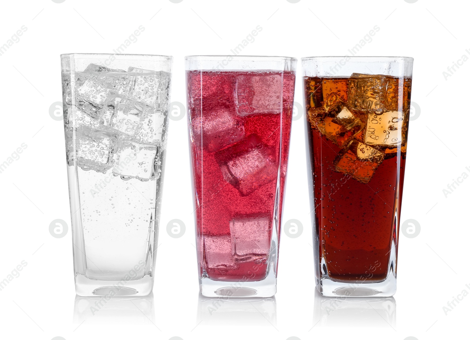 Photo of Soda water of different flavors with ice cubes in glasses isolated on white