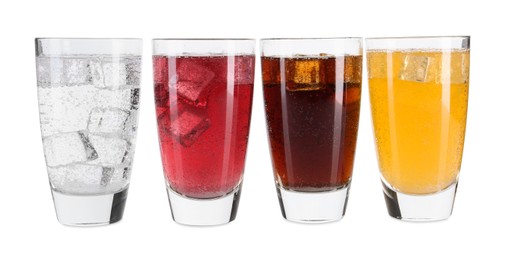 Photo of Soda water of different flavors with ice cubes in glasses isolated on white