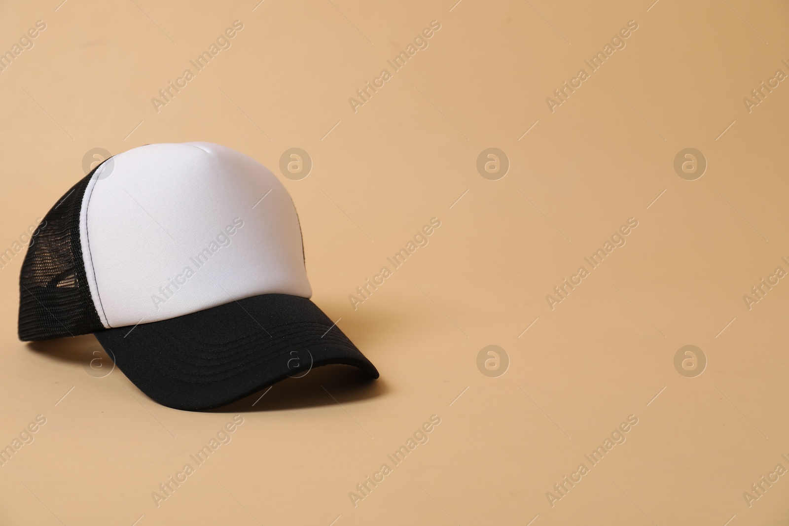 Photo of Blank baseball cap for branding on beige background. Mockup for design