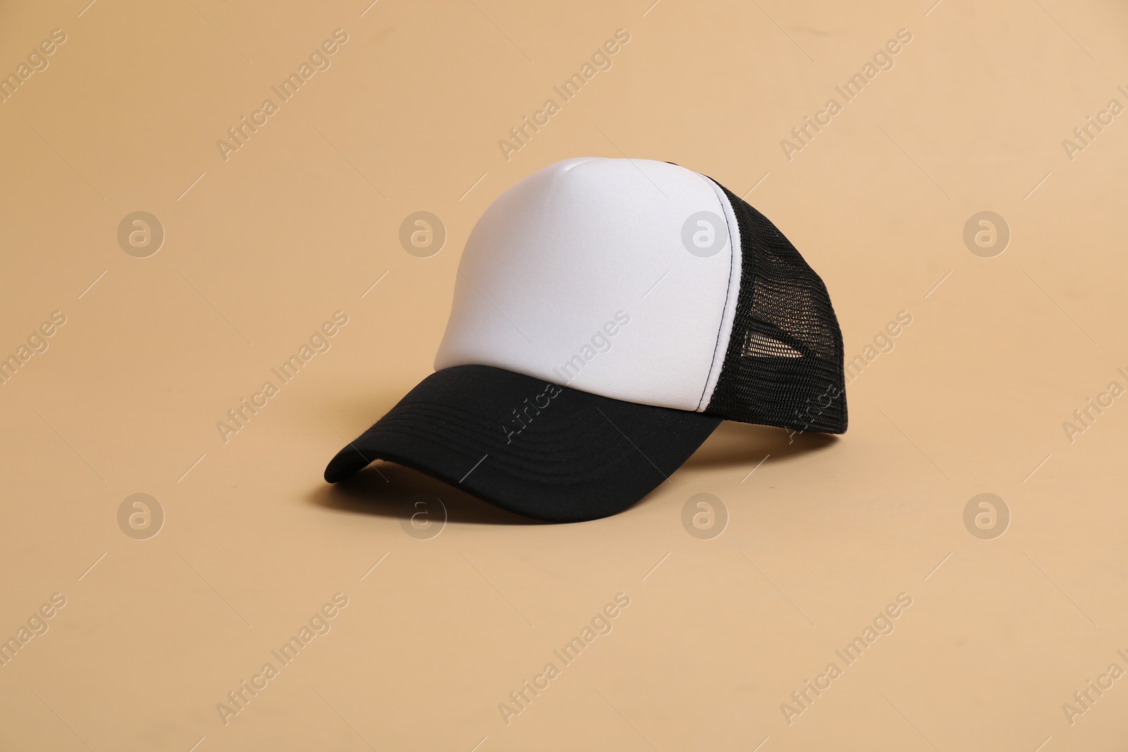 Photo of Blank baseball cap for branding on beige background. Mockup for design