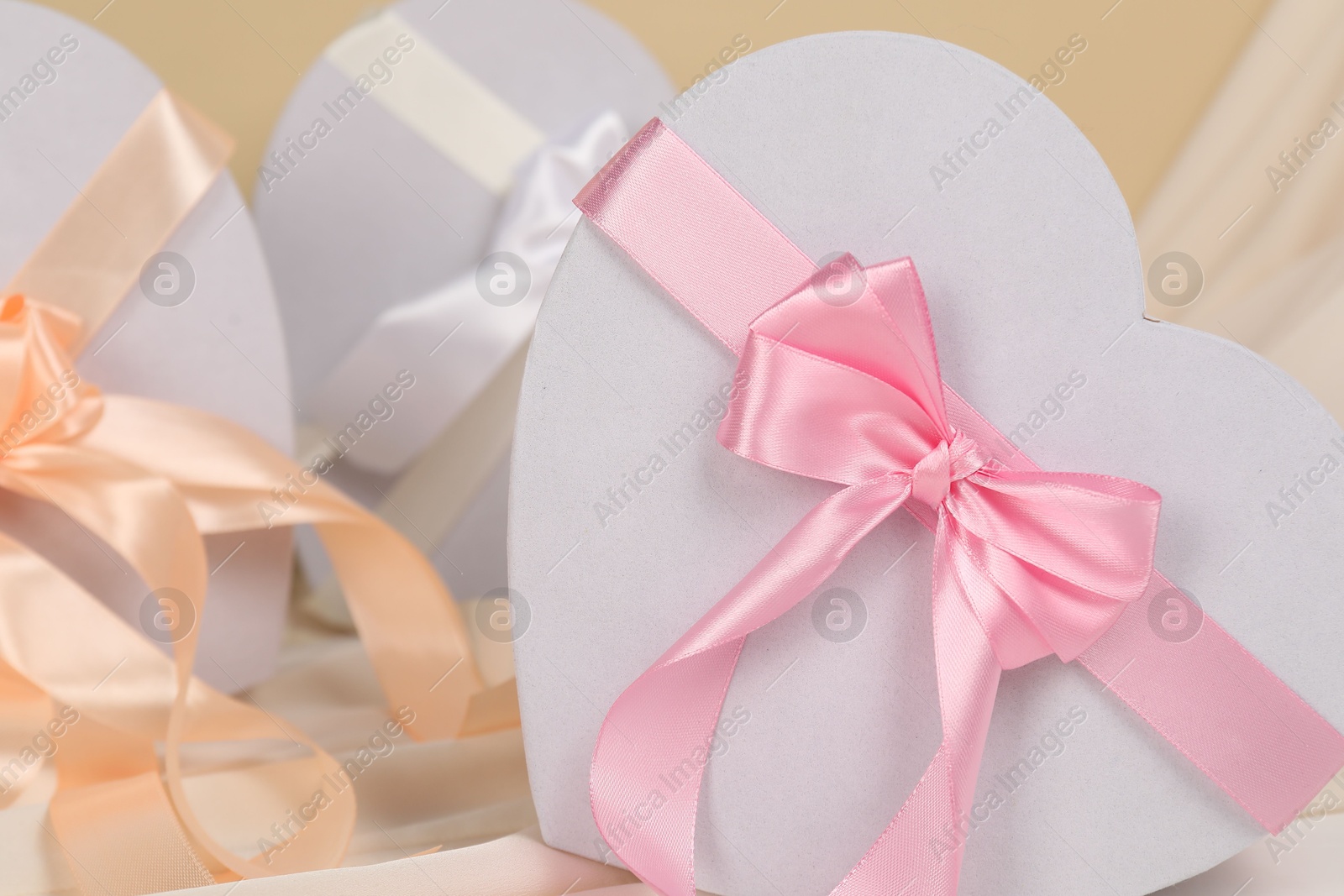 Photo of Beautiful wedding gifts and silk fabric on table, closeup