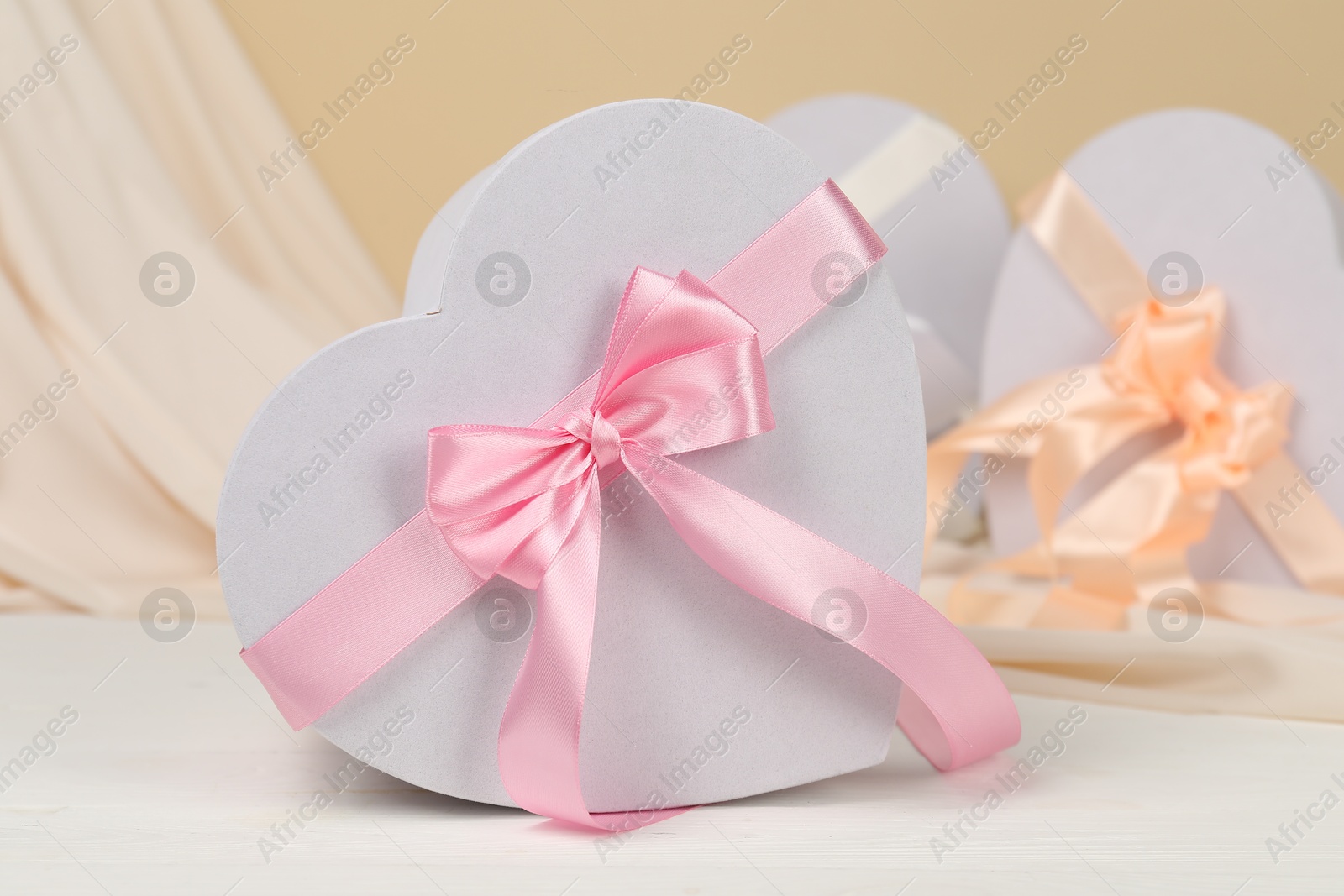 Photo of Beautiful wedding gifts and silk fabric on white wooden table