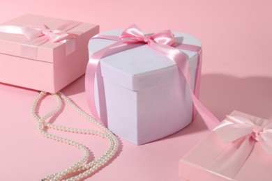 Photo of Beautiful wedding gifts and pearl jewelry on pink background