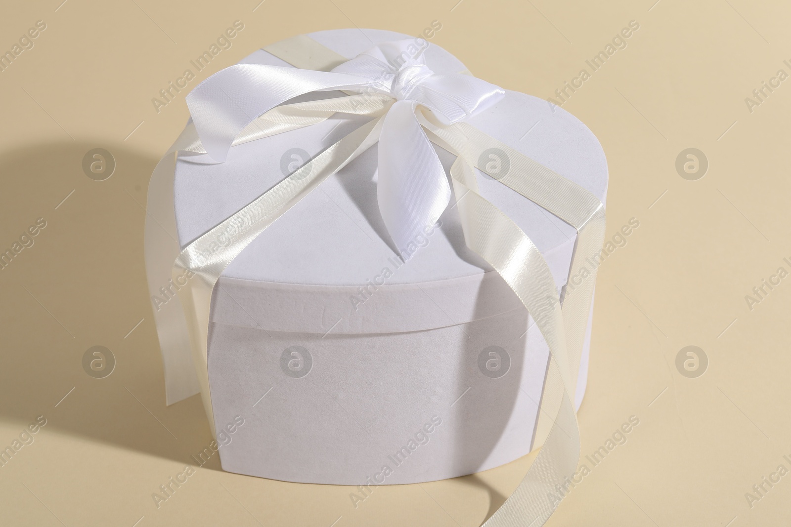 Photo of Beautiful wedding gift on beige background, closeup