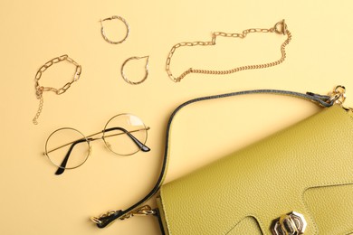 Photo of Beautiful bag and stylish accessories on beige background, flat lay