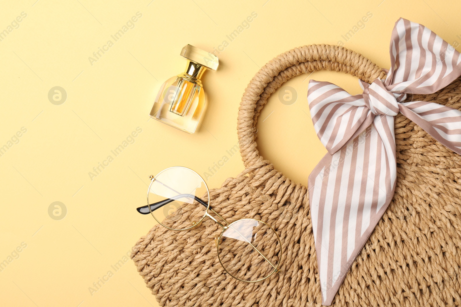 Photo of Stylish accessories. Beautiful bag, perfume and sunglasses on beige background, flat lay. Space for text