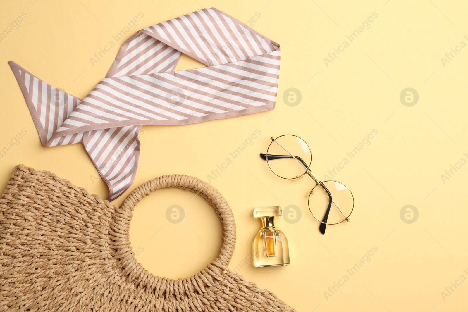 Photo of Beautiful bag, perfume and stylish accessories on beige background, flat lay. Space for text