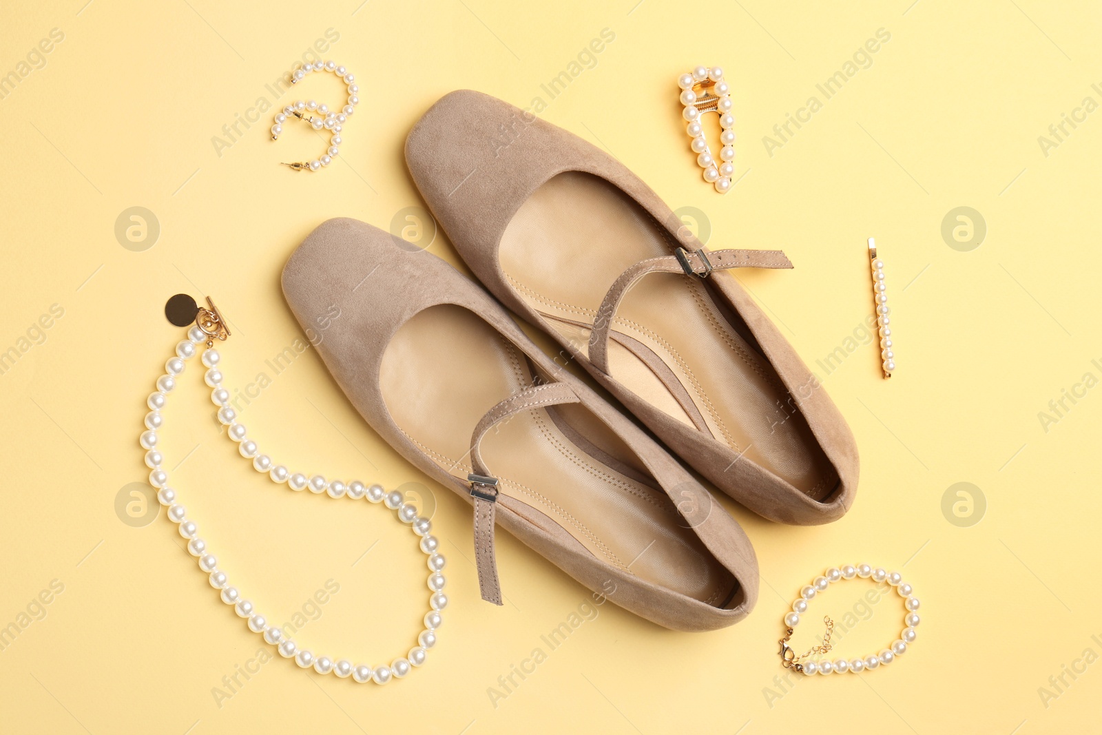 Photo of Shoes and stylish accessories on beige background, flat lay