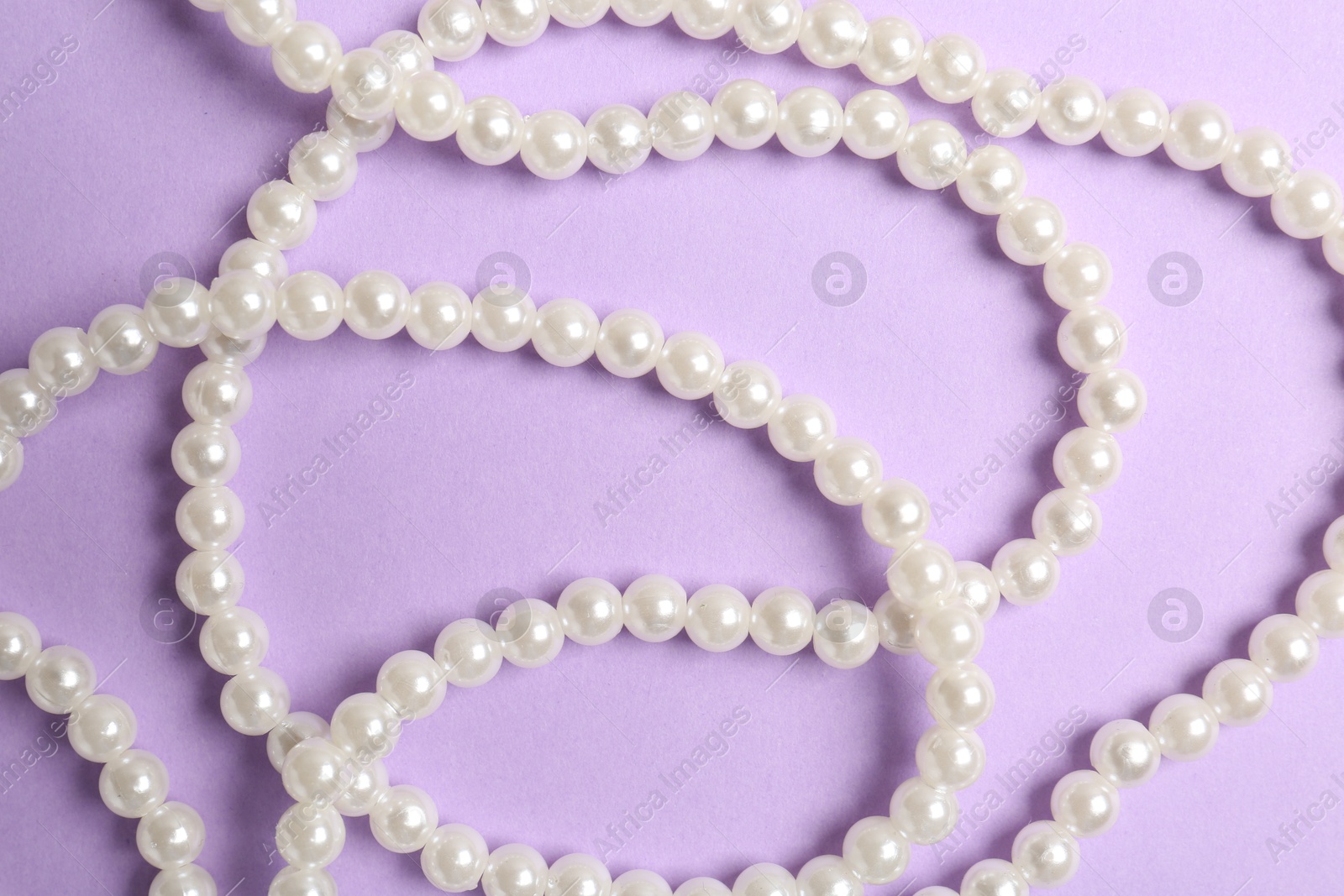 Photo of Stylish accessories on lilac background, flat lay