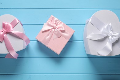 Photo of Beautiful wedding gifts on light blue wooden table, flat lay