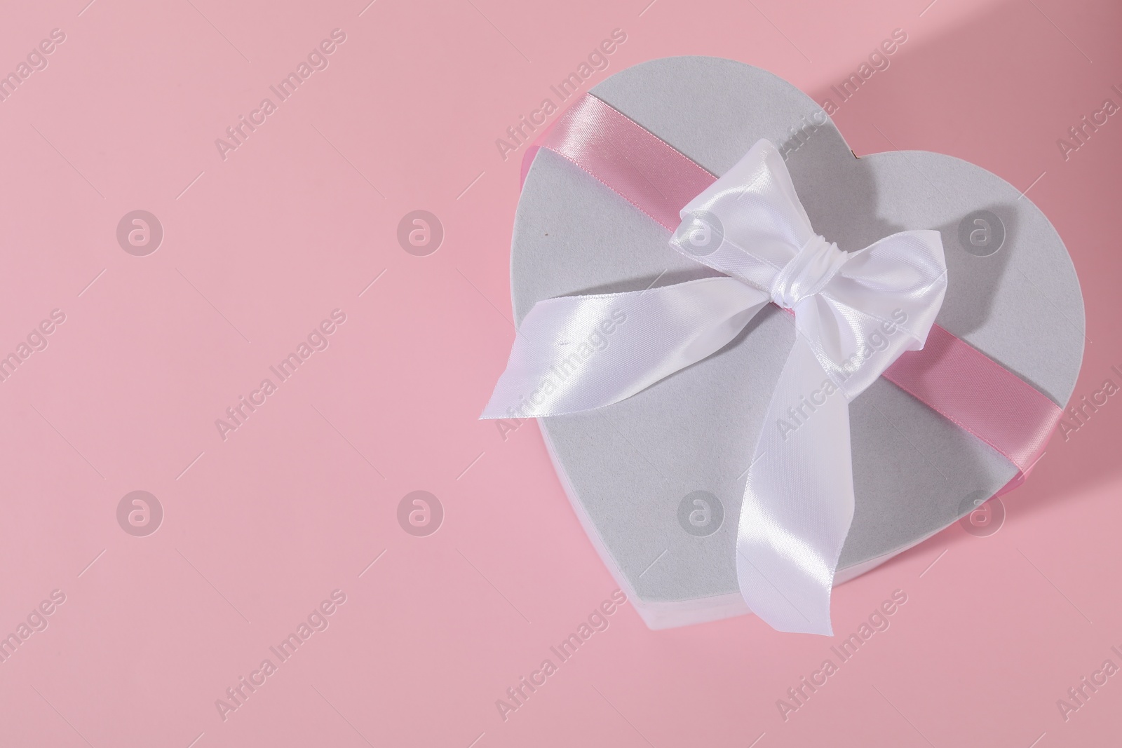 Photo of Beautiful wedding gift on pink background, top view. Space for text