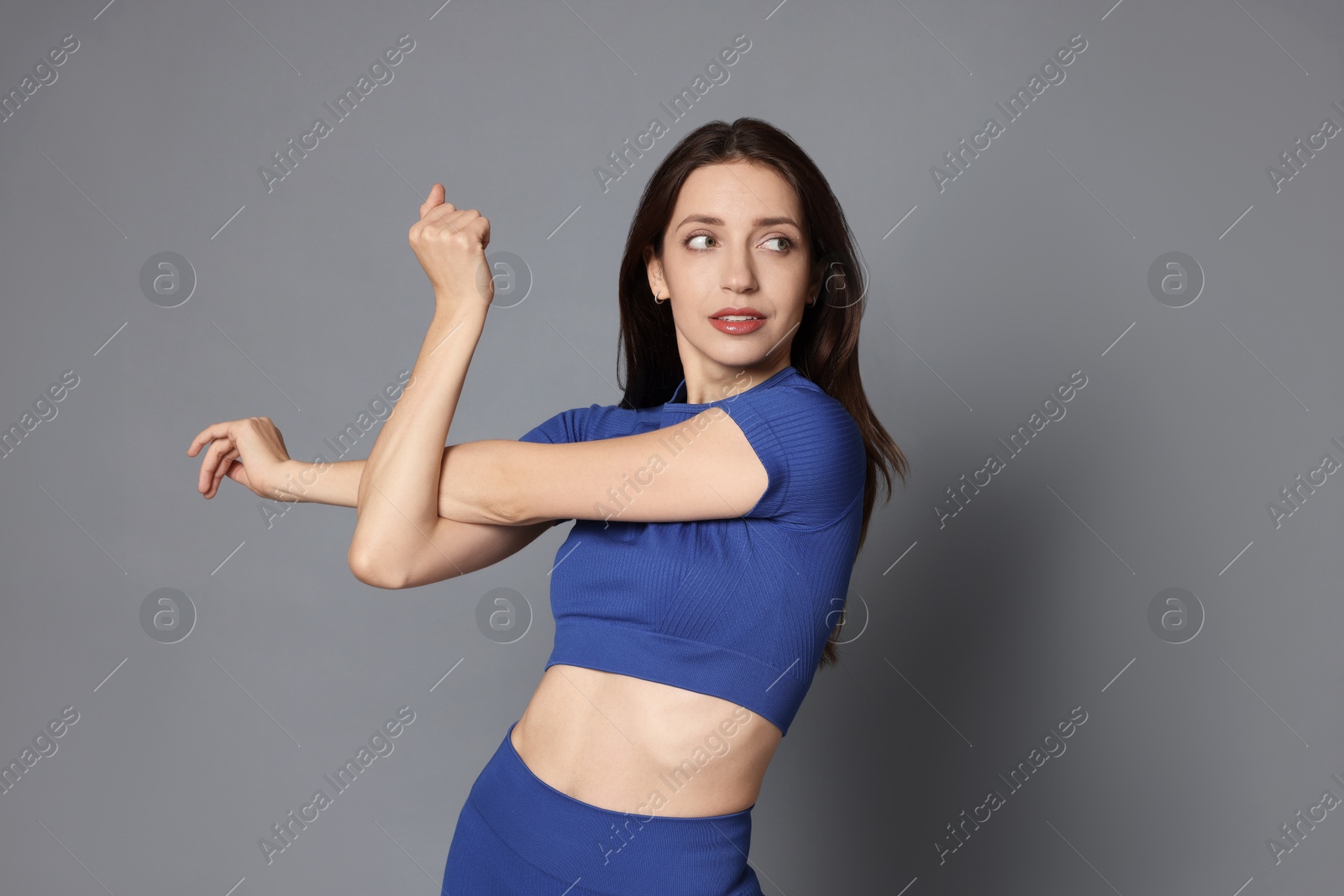 Photo of Beautiful woman in stylish sportswear on grey background