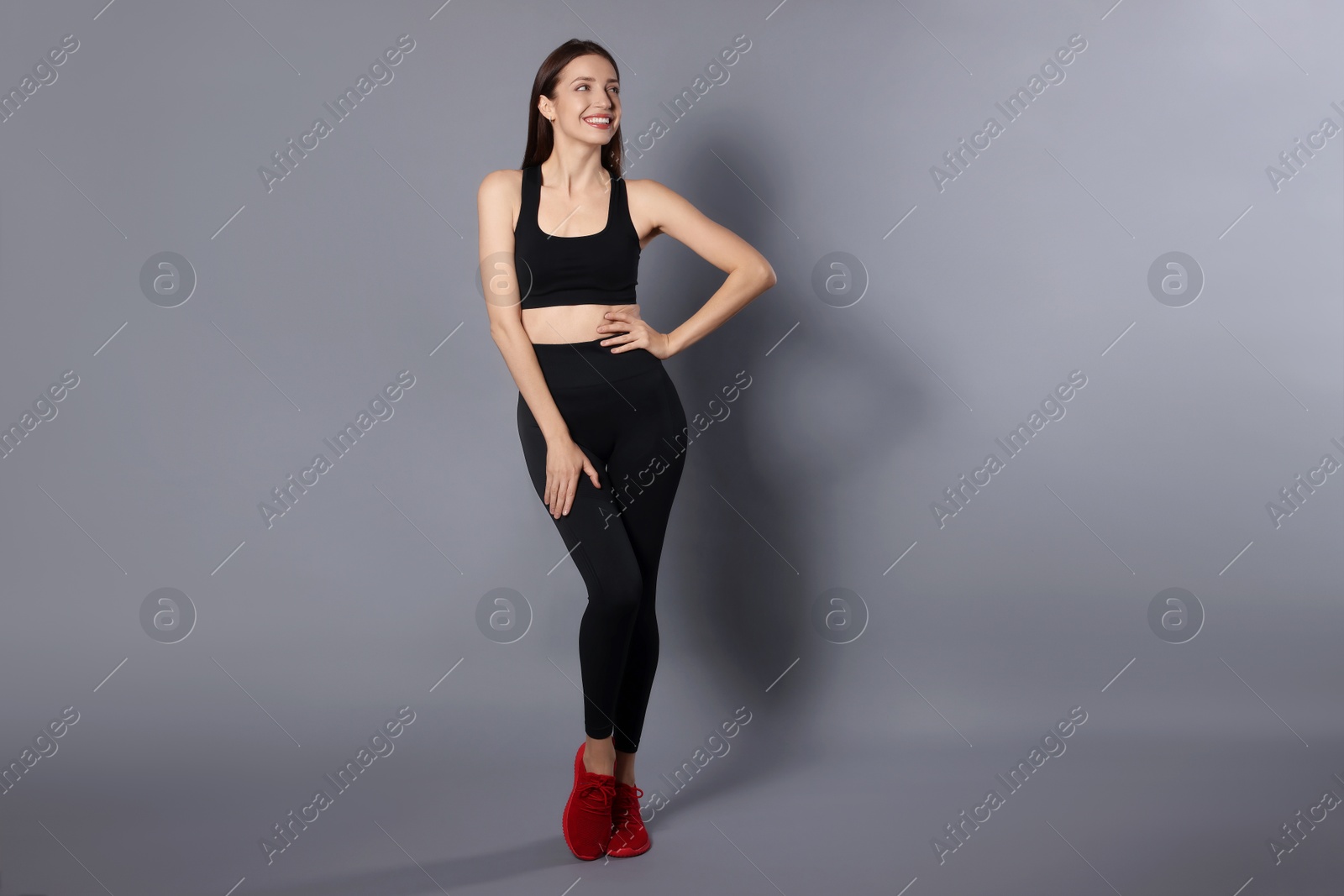 Photo of Beautiful woman in stylish sportswear on grey background