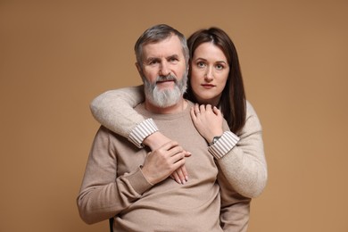 Photo of Family portrait of daughter and her father on light brown background