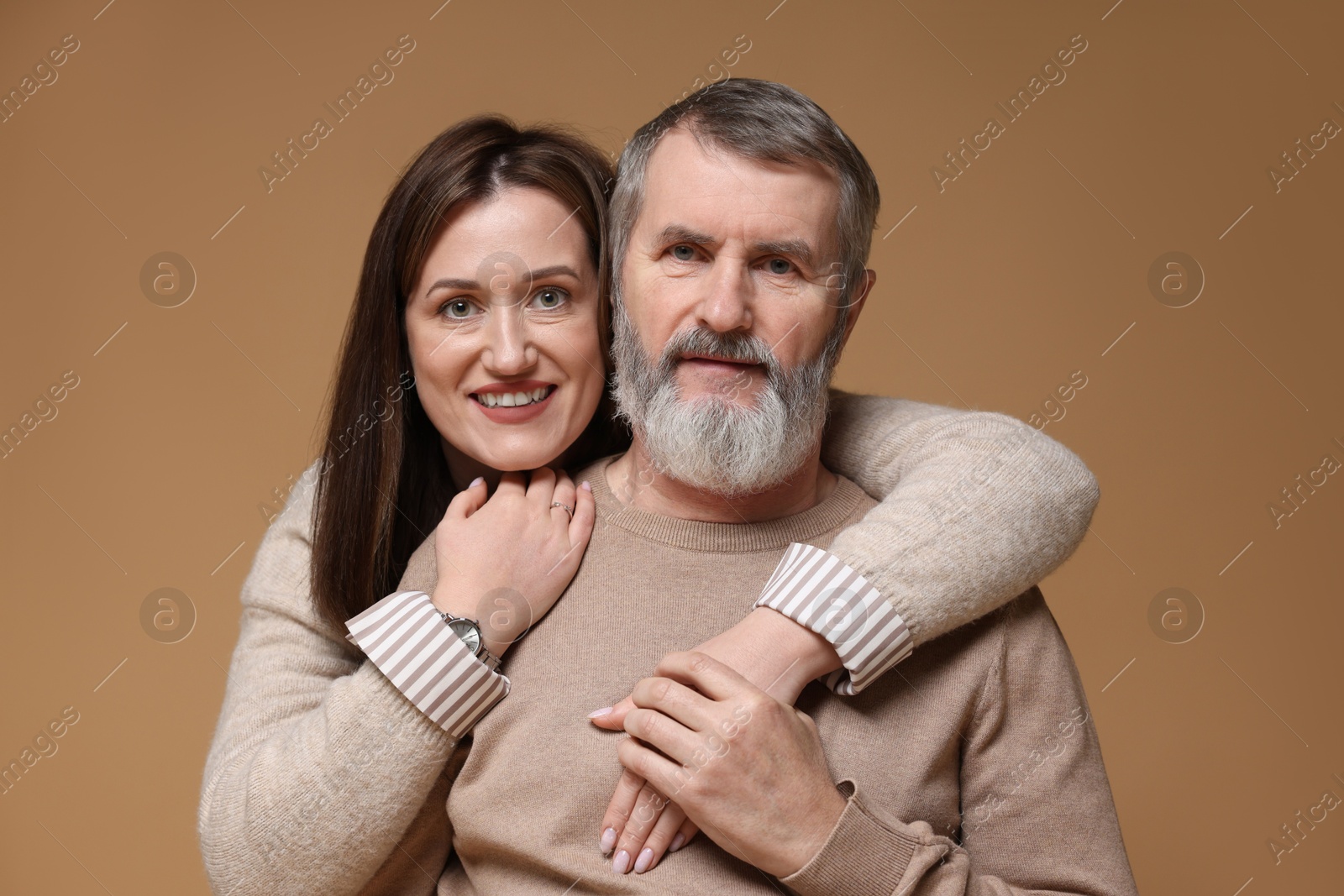 Photo of Family portrait of happy daughter and her father on light brown background