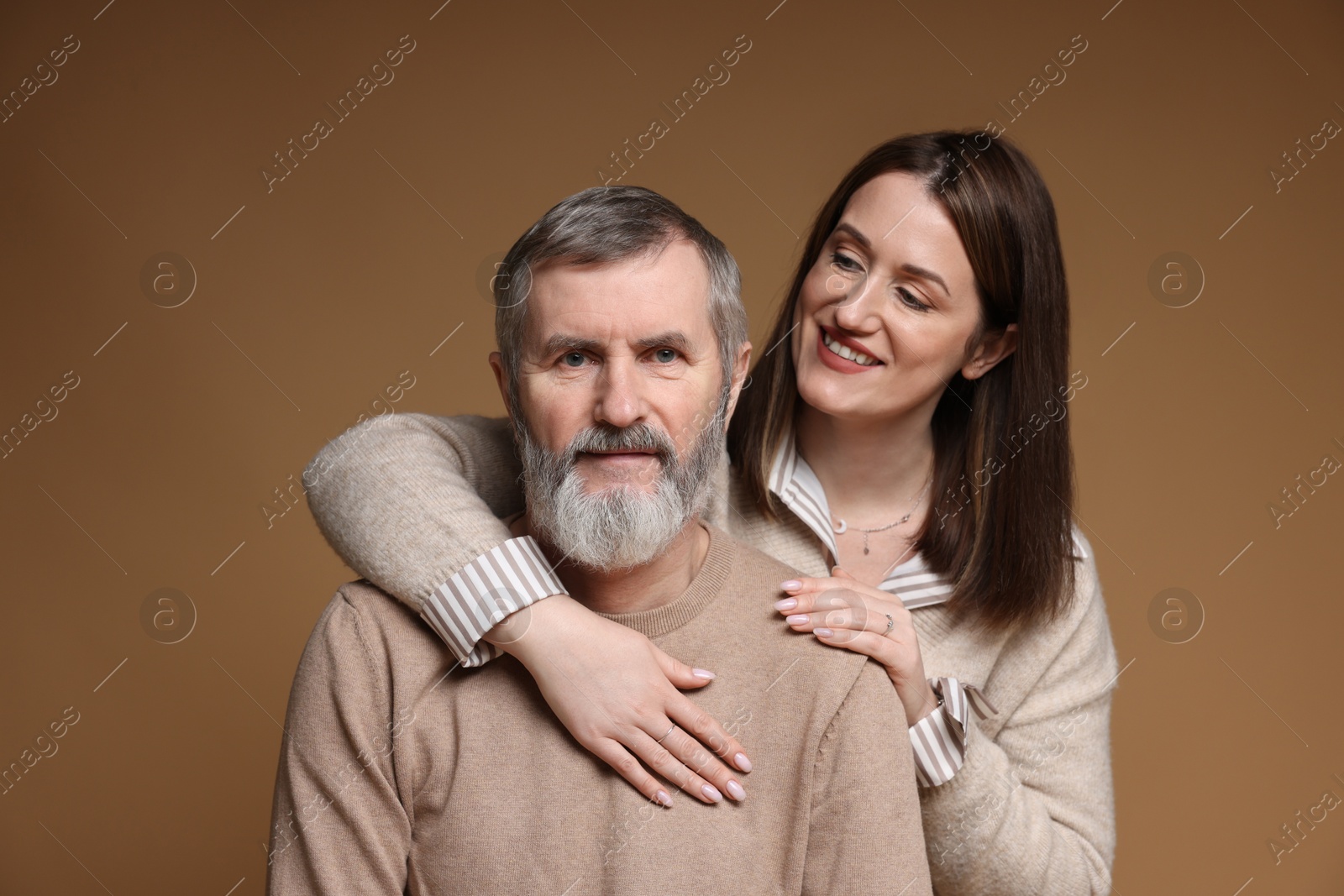 Photo of Family portrait of happy daughter and her father on brown background