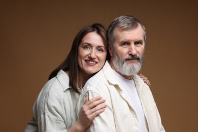 Photo of Happy daughter and her father on brown background