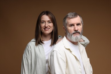 Photo of Family portrait of happy daughter and her father on brown background