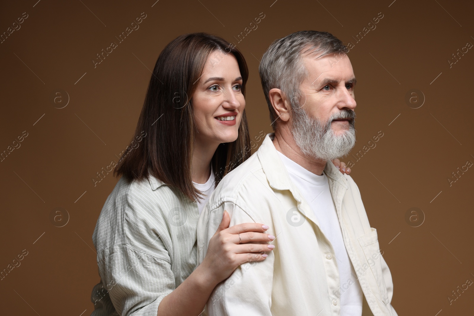 Photo of Happy daughter and her father on brown background