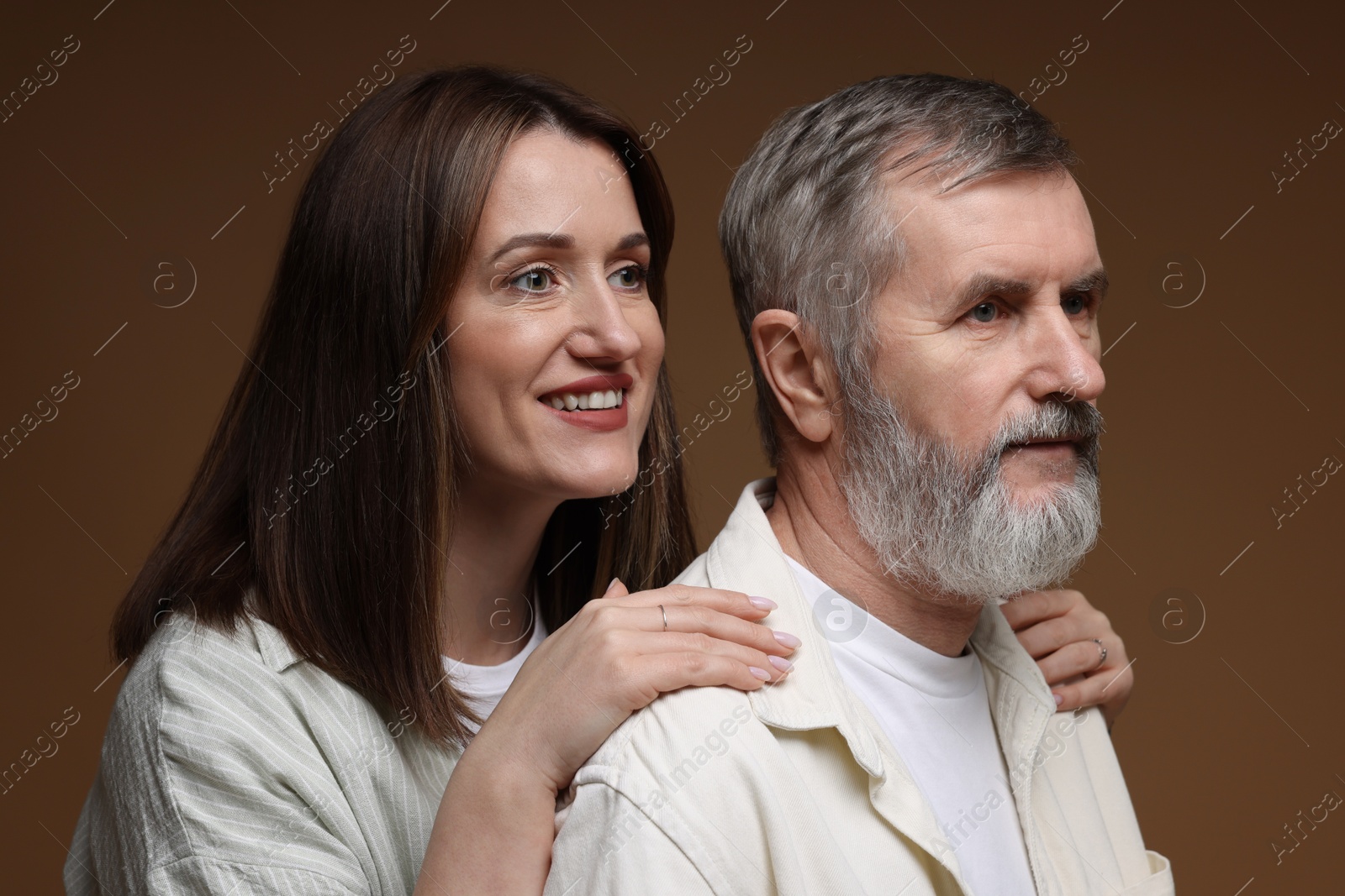 Photo of Happy daughter and her father on brown background