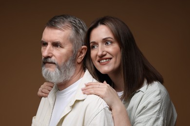 Photo of Happy daughter and her father on brown background