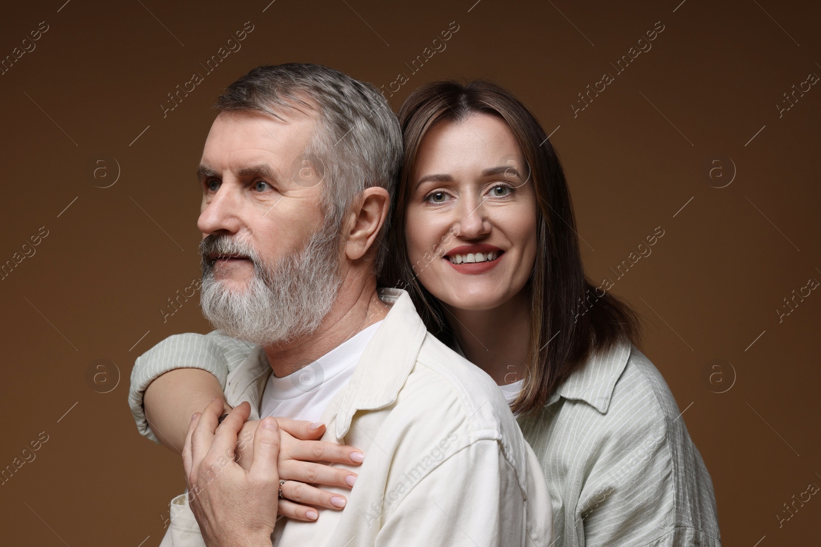 Photo of Happy daughter and her father on brown background