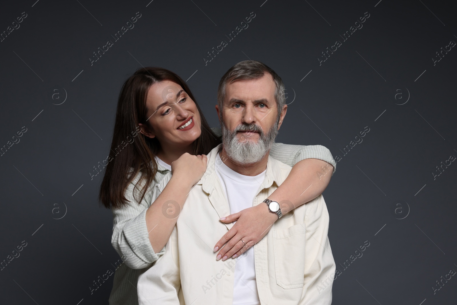 Photo of Happy daughter hugging her father on dark background