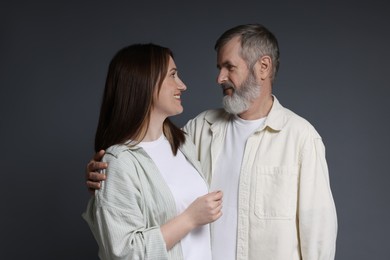 Photo of Happy daughter and her father looking at each other on dark background