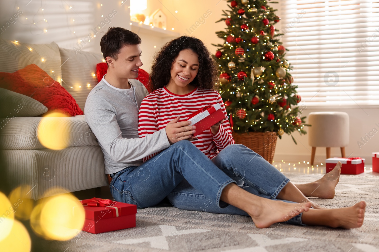 Photo of Happy couple with Christmas gifts spending time together at home