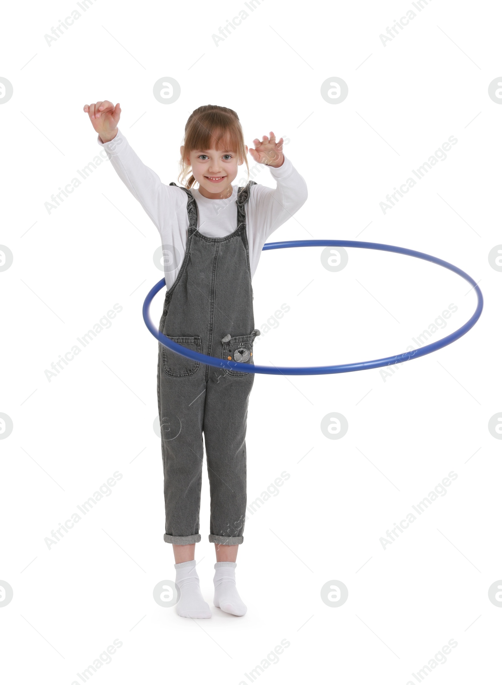 Photo of Cute little girl exercising with hula hoop on white background