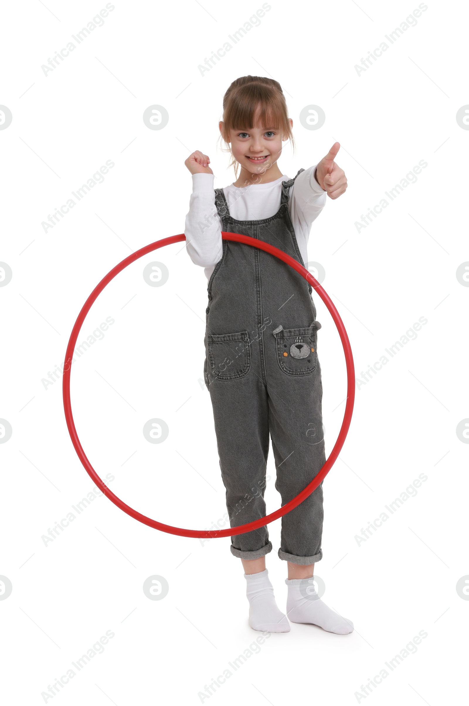 Photo of Cute little girl with hula hoop showing thumbs up on white background