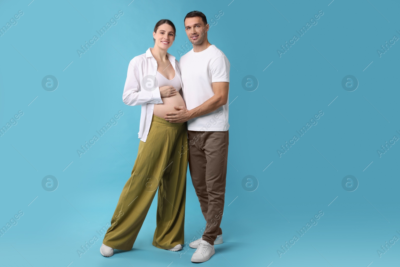 Photo of Pregnant woman and her husband on blue background